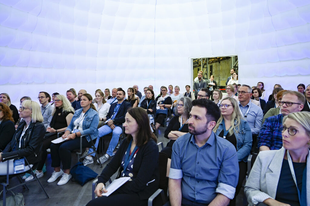 Menschen in einem aufblasbaren Quickspace Dome während einer Masterclass des Vergabesymposiums